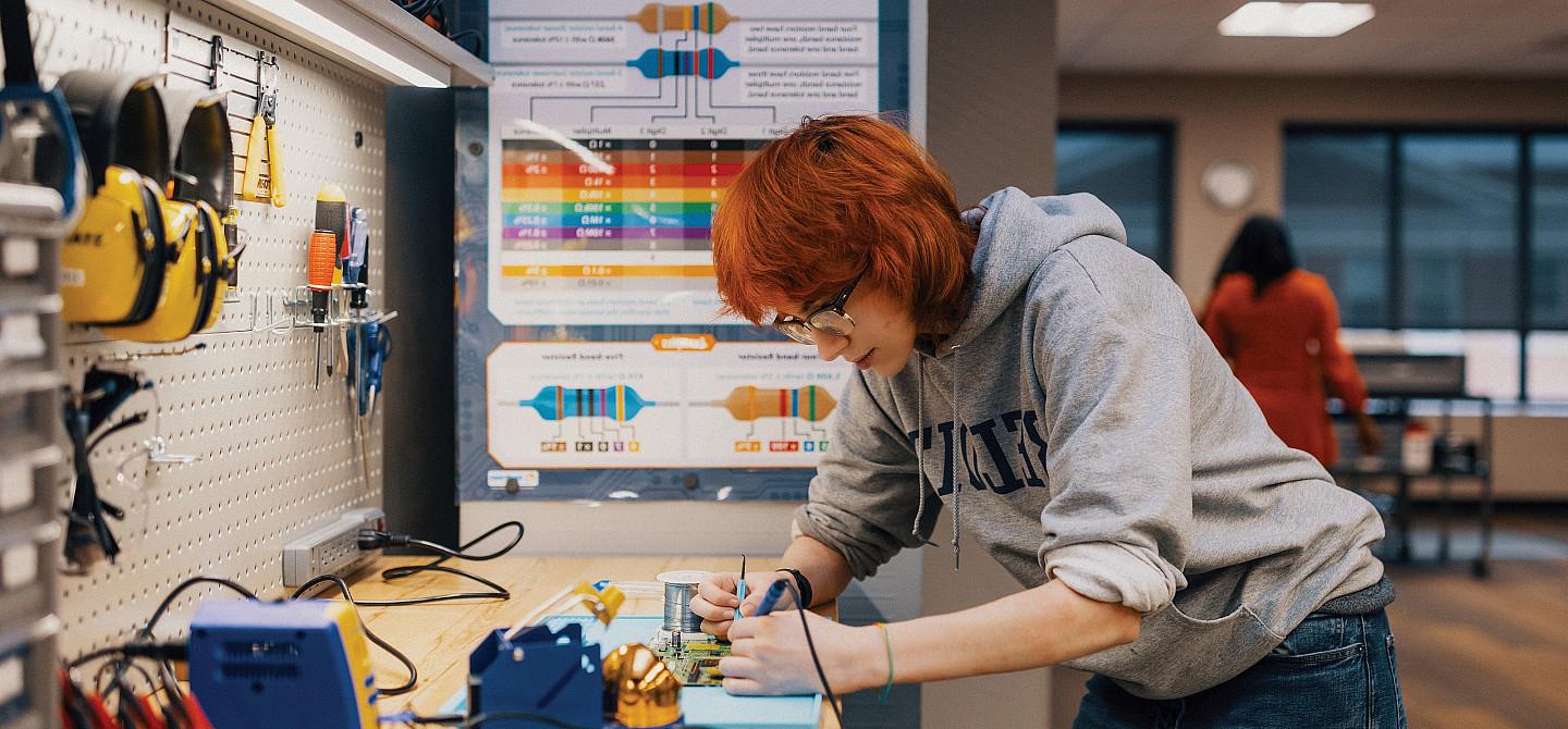 Maker Lab supervisor Adwyn Burdett'27 experiments with a motherboard.